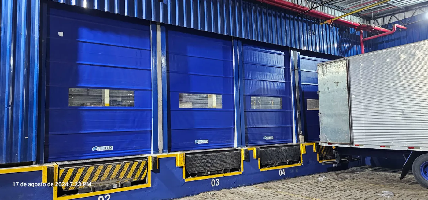 Portas rápidas Visoflex VFX501 azuis de grande vão em docas com caminhão