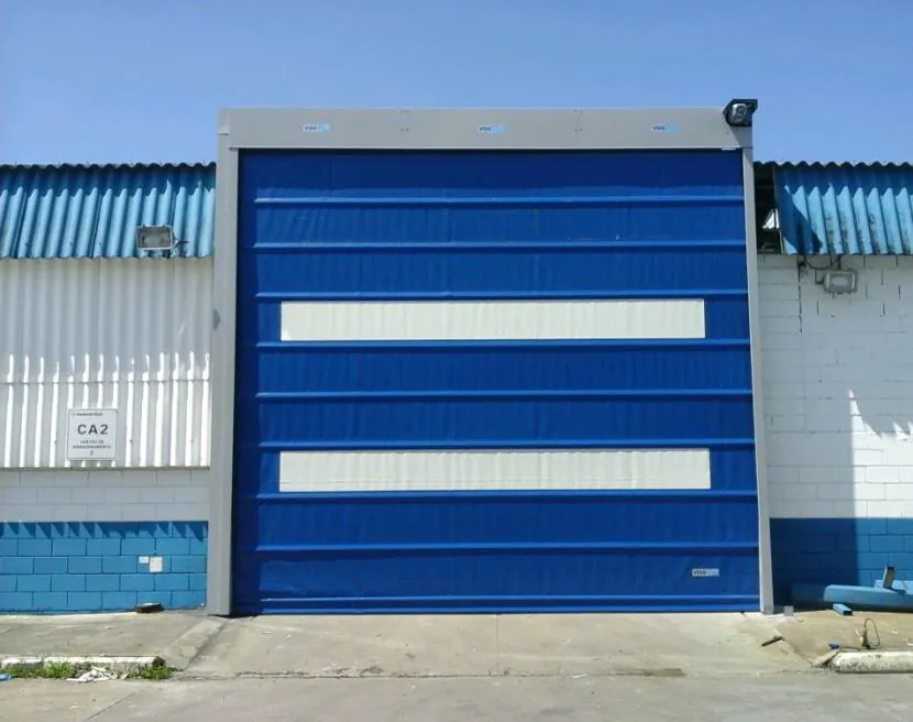 Porta rápida Visoflex VFX501 azul de grande vão com dois visores em fachada externa de galpão