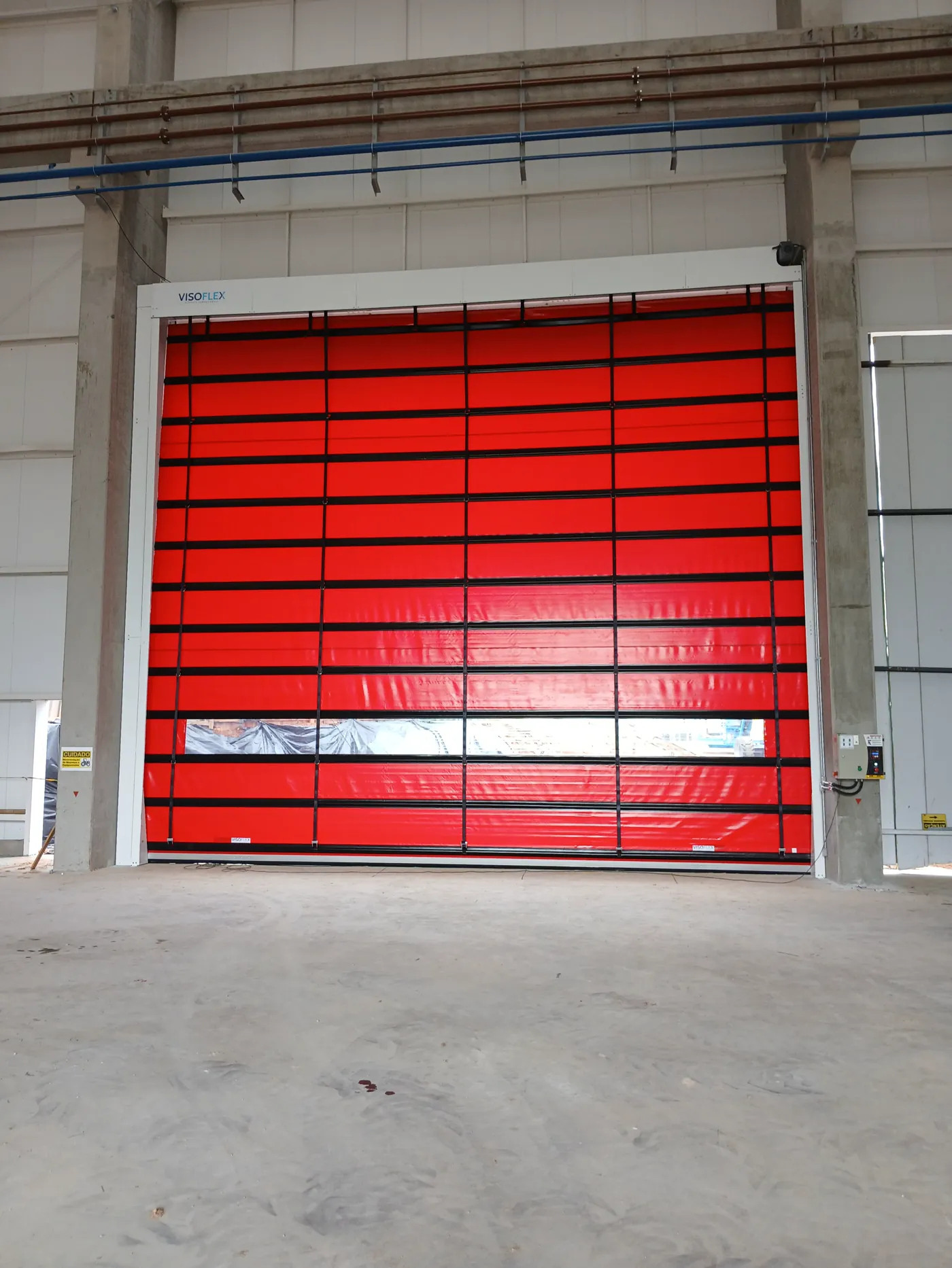 Porta rápida Visoflex VFX501 vermelha de grande vão com visor em galpão industrial