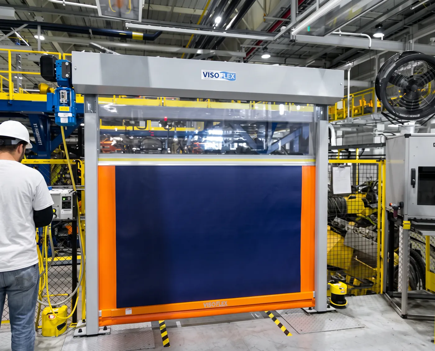 Porta rápida Visoflex VFX302 Safety azul e laranja com visor em linha de montagem automotiva, com operador ao lado