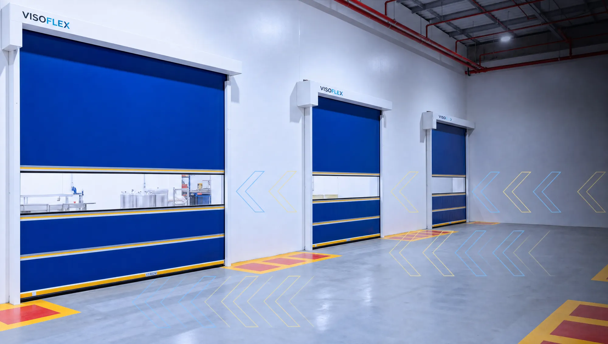 Três portas rápidas Visoflex azuis com visor em parede industrial, com setas da marca no piso e na parede
