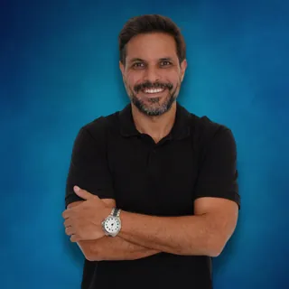 Roberto Basso, CEO da Visoflex, sorrindo de braços cruzados com camisa polo preta