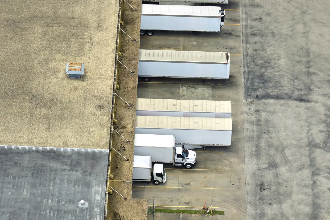 Vista aérea de centro de distribuição com caminhões nas docas