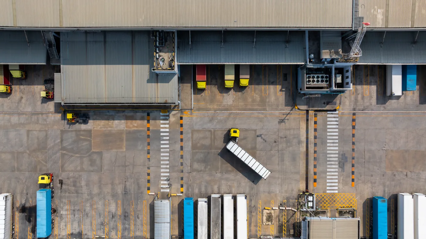 Vista aérea de carretas estacionadas nas docas de um centro logístico