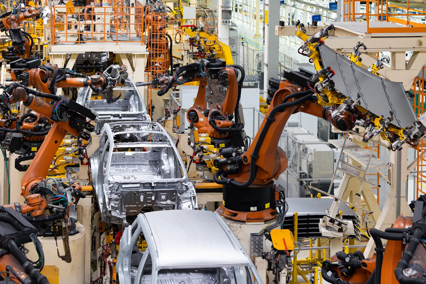 Carrocerias de carro em linha de montagem com braços robóticos