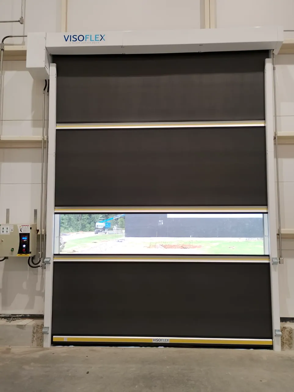 Porta rápida VFX302 com lona escura e visor full instalada em área industrial
