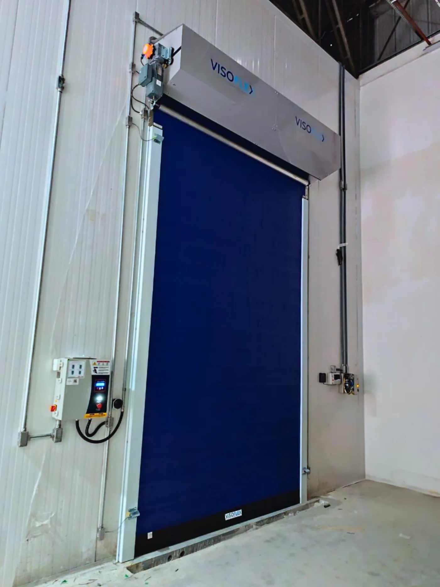 Porta rápida Visoflex VFX602 azul com lona isolada em câmara frigorífica, com quadro de comando ao lado