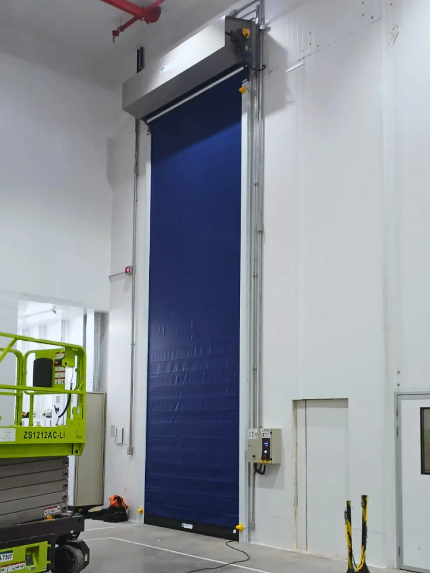 Porta rápida Visoflex VFX602 azul em vão alto de câmara frigorífica com painéis isotérmicos brancos
