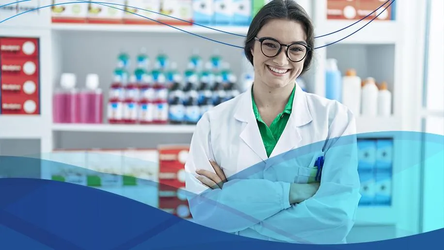 Farmacêutica sorridente de jaleco branco diante de prateleiras de medicamentos