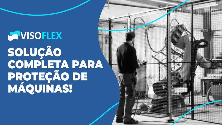 Operador diante de célula robótica protegida por grade de segurança